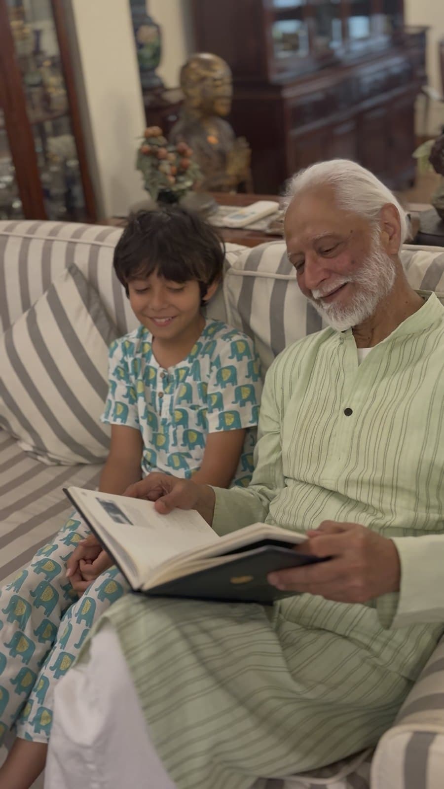 A grandfather reading the finished book together with his grandson