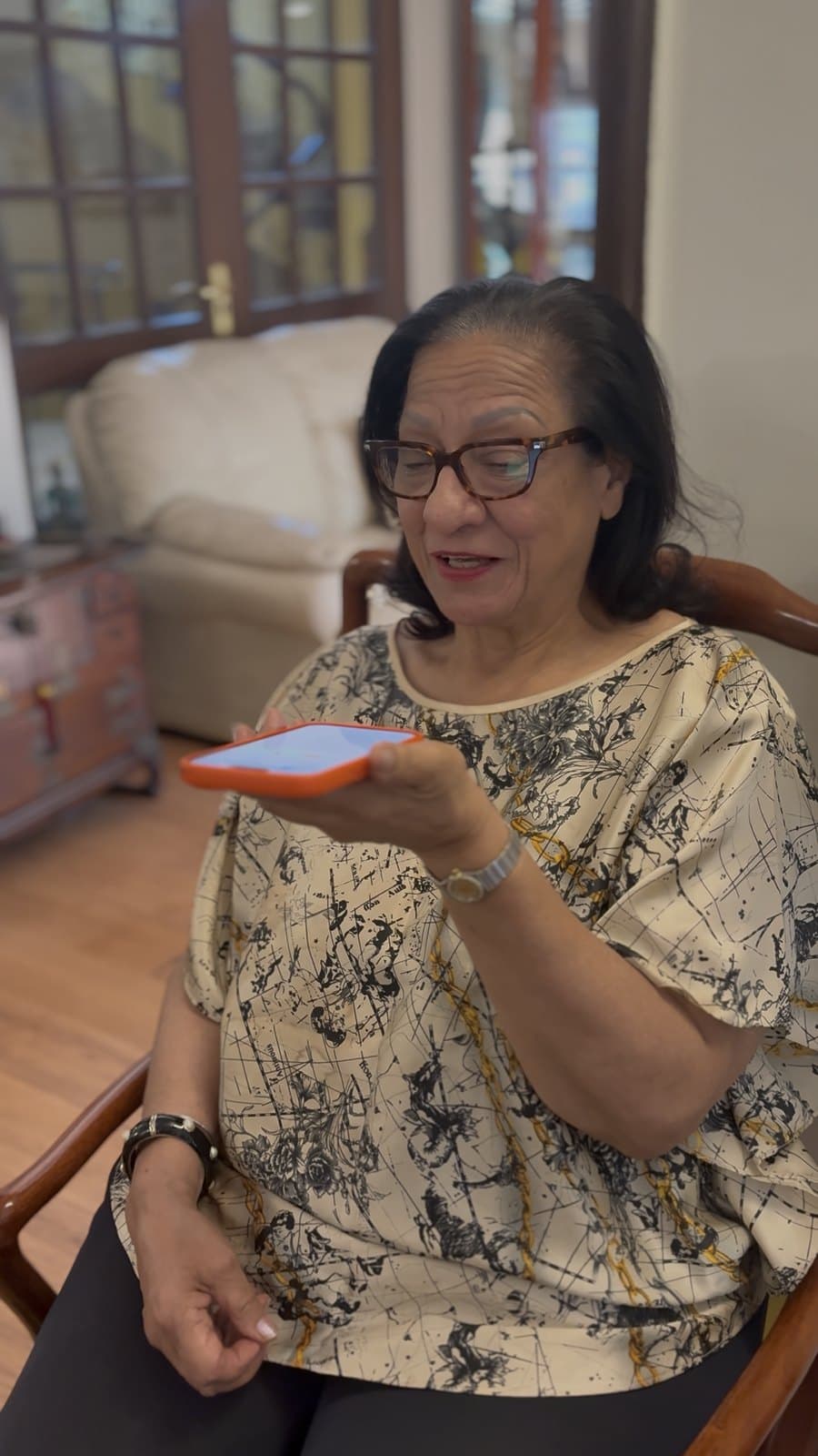 A grandmother recording a voice note reply on her phone